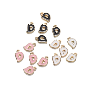 Detail view of D-shaped enamel letter charms in black, white, and pink with gold plating