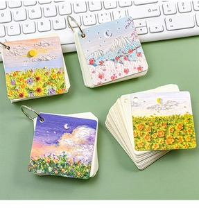 Macro detail of oil painting style pocket notebooks with metal rings on a desk