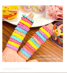 Colorful macaron wavy hair ties set in a transparent box on a wooden surface