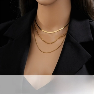 Detail of gold-layered titanium steel necklace with herringbone and figaro chains