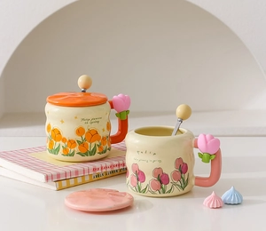 Detail of pink and orange ceramic tulip mugs with flower-shaped handles and lids