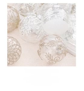 Detailed view of clear Christmas baubles with white snowflake and gold glitter patterns