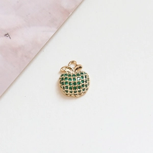 Detailed view of apple pendant with green cubic zirconia in gold plating for jewelry making