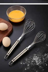 Detail of 304 stainless steel whisks with hanging loops on professional dark surface
