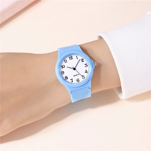 Close-up of a light blue minimalist quartz watch with silicone strap on a female wrist