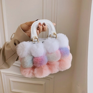 Detail of colorful plush handbag with white handle and gold metal ring hardware