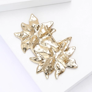 Detail view of the golden alloy Christmas brooch back with safety pin clasp and texture