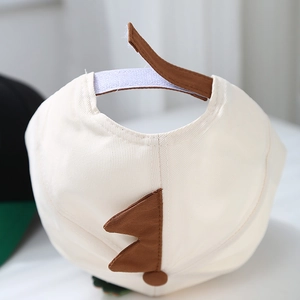 Détail de la casquette beige pour enfant avec pointes de dinosaure et velcro brun