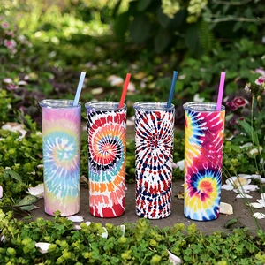 Tie-dye stainless steel skinny tumblers with straws shown in a natural outdoor setting