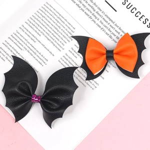 Detail of Halloween bow hair clips featuring black bat wings in orange and purple glitter