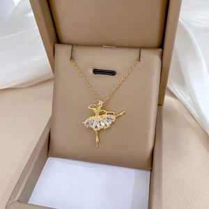 Golden ballet girl pendant necklace with sparkling crystals on white silk fabric