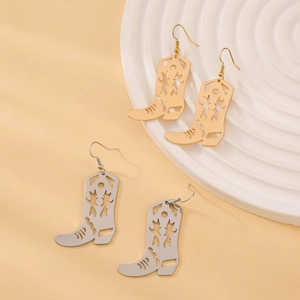 Détail des boucles d'oreilles en forme de bottes de cowboy en or et argent