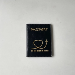 Classic black leather passport holder featuring gold embossed text and heart airplane icon