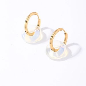 Détail de boucles d'oreilles dorées en acier inoxydable avec pendentifs ronds translucides