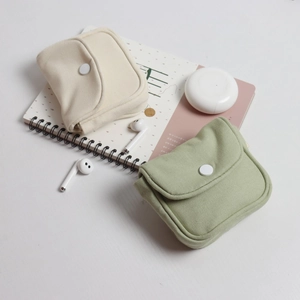 Detail of canvas pouches in off-white and light green with round snap button closure