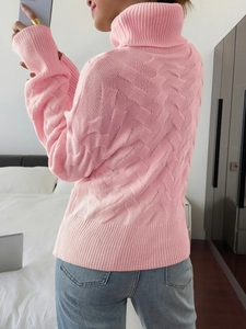 Detailed back view of a pink knit sweater with cable texture and ribbed turtleneck