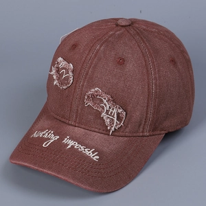 Dettaglio cappello da baseball in denim marrone effetto usurato con ricamo sulla visiera