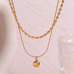 Close-up of double-layered 18K gold plated necklace with beads and spherical pendant