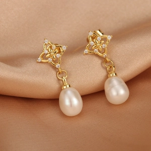 Detailed macro view of 18K gold plated floral earring with freshwater pearl and zircon