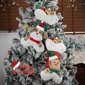 Christmas bone stockings with cartoon cat and dog patterns hanging on a snowy tree