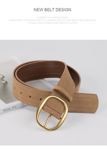Détail d'une large ceinture en cuir marron mat avec une boucle en métal doré ovale