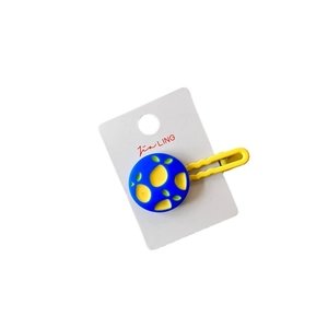 Colorful geometric hair clip with yellow lemon pattern on blue circular plastic base