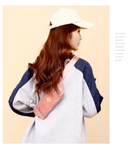 Detailed view of pink crossbody bag with zipper and colorful R letter pattern on model