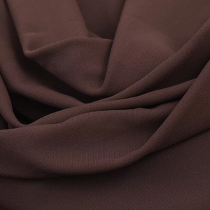 Detailansicht der dunkelbraunen Strickstruktur mit weichem Faltenwurf und feinen Fasern