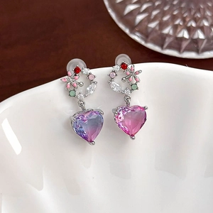 Macro detail of silver zircon earrings with gradient purple heart crystal and floral motif
