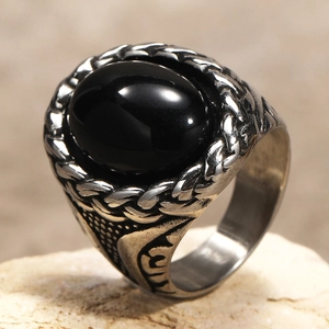 Detail of vintage men's ring with oval black gemstone and intricate woven silver patterns
