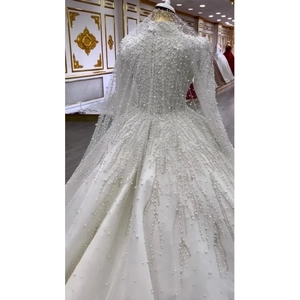 Detail of luxury bridal gown with heavy pearl embroidery and shimmering sequins on sleeves