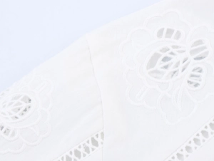 Vista macro dettagliata del ricamo in cotone bianco e dei motivi in tessuto traforato