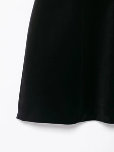 Vue détaillée de l'ourlet de la robe en velours noir montrant la texture du tissu