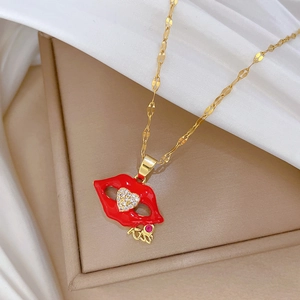 Elegant gold necklace with red lips and zircon heart pendant on a luxury gift box