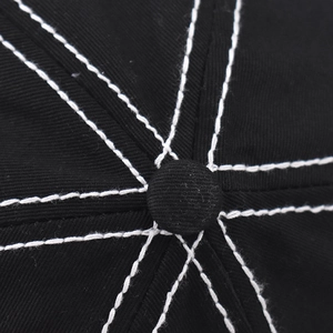 Macro view of cotton twill baseball cap top with contrast white stitching and button