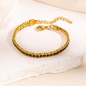 Detail of gold chain bracelet featuring black zircon stones and adjustable lobster clasp