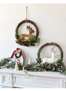 Christmas rattan wreath with elk, pine cones and berries on white wall backdrop