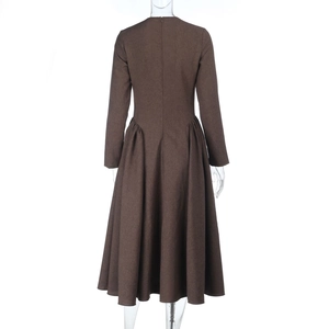 Detail of long sleeve brown dress featuring linen texture and wide pleated A-line skirt back