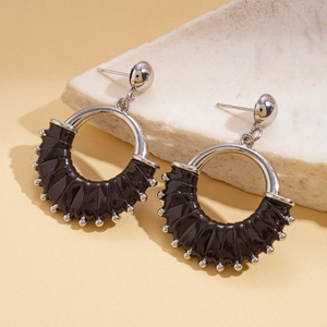 Detail view of retro geometric round earrings with black leather and silver bead accents