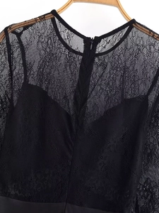 Detail shot of black lace dress showing round neckline and invisible back zipper
