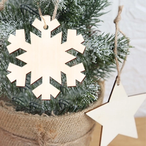 Hanging wooden snowflake and star ornaments on a mini Christmas tree with jute rope