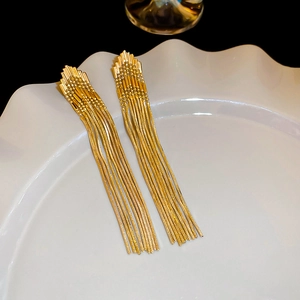 Vintage-Gold-Ohrringe mit Quastenkette und Dreieck-Pfeil-Design auf weißem Teller