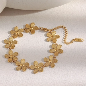 Detail of 18K gold daisy bracelet showing floral petals and 18K hallmark tag