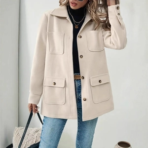 Detail of beige wool shacket featuring four front pockets and contrasting brown buttons