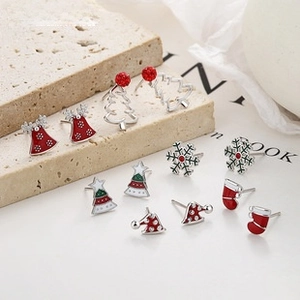 Detail of Christmas earring set with enamel festive charms like bells and snowflakes