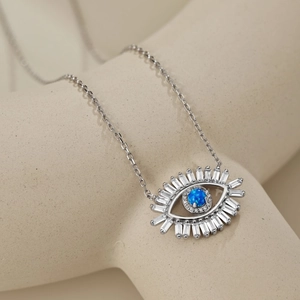 Macro detail of S925 silver Evil Eye necklace with blue opal and baguette zircon stones