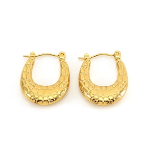 Macro detail of gold U-shaped hoop earrings with textured crocodile pattern finish