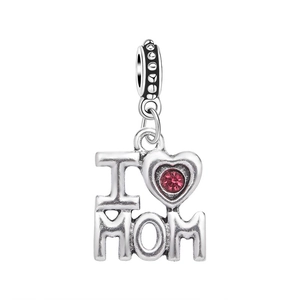 Macro shot of silver I Love Mom pendant with a red gemstone heart detail