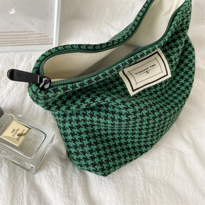Close-up of green houndstooth makeup bag with woven Pleasant Time label and zipper