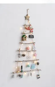 Detail of wooden branch Christmas tree wall hanging with LED lights and pine cones